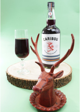 Botella de Vino Caribou con copa llena, aperitivo folclórico tradicional de Quebec al 22,9%