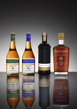 Cinco botellas Sortilège alineadas, gama completa de licores con jarabe de arce