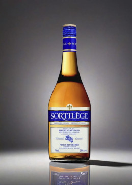 Sortilège blueberry bottle with gold label and blue cap, close-up view