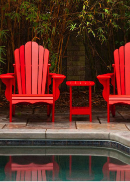 Chaise rouge au bord d'une piscine